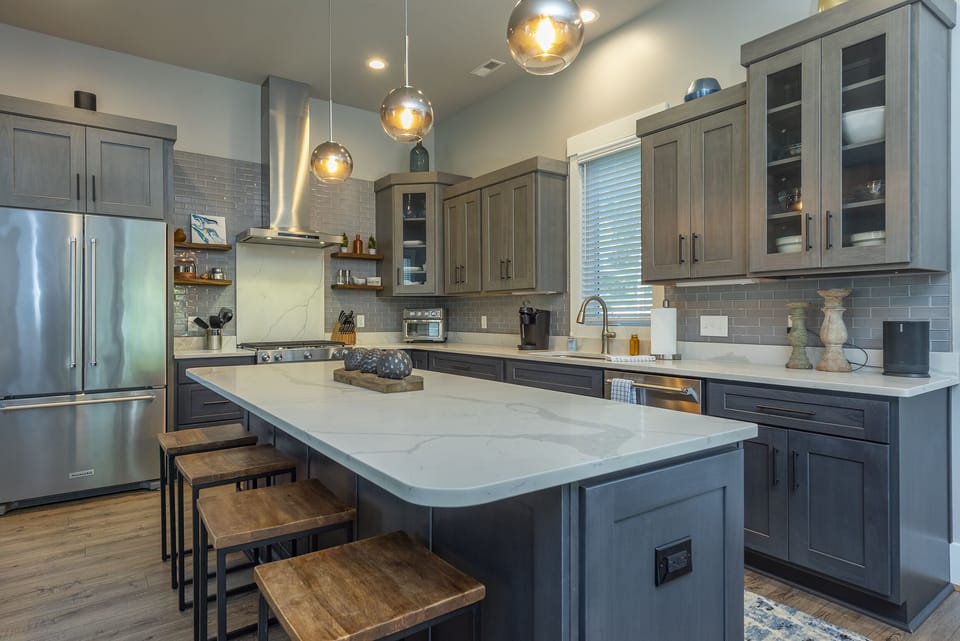 Gourmet kitchen with island seating for 4, gas range stove, Keurig coffeemaker & Sonos Sound System.