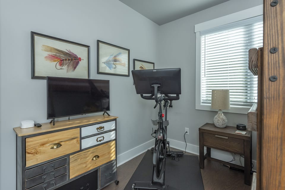 Upper-level bedroom with Full-size bunk bed & Peloton bike.