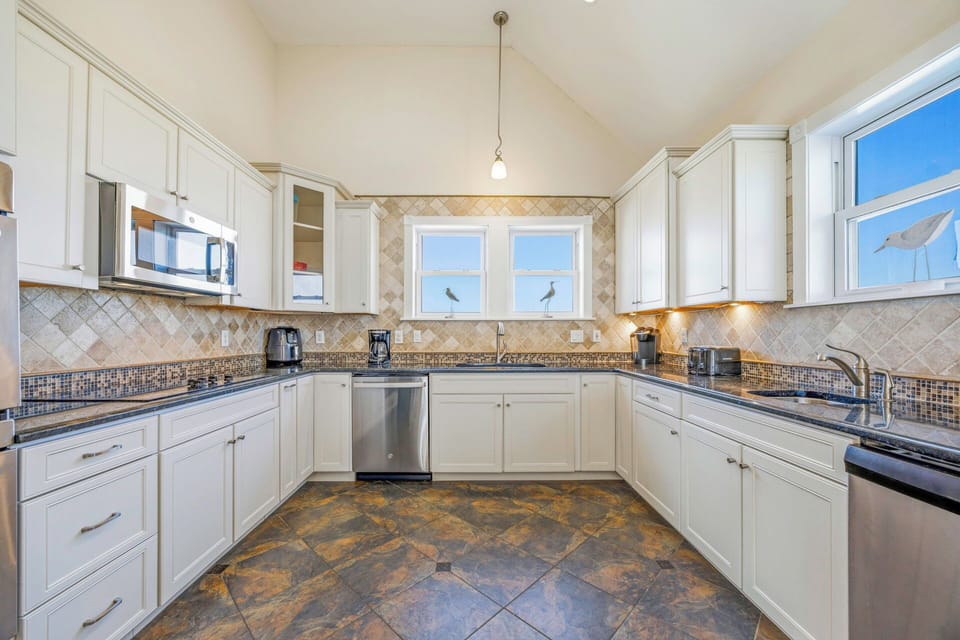 Your spacious kitchen features elegant white cabinets, granite countertops, and modern stainless steel appliances for all your culinary adventures.