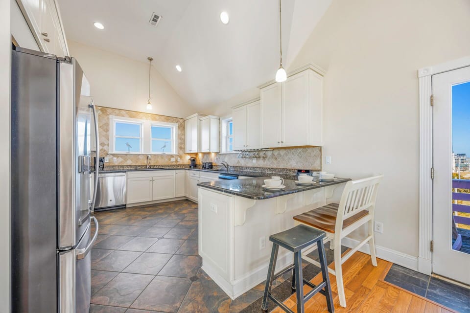 Cook your favorite meals in this elegant kitchen with granite counters, white cabinets, and modern appliances.