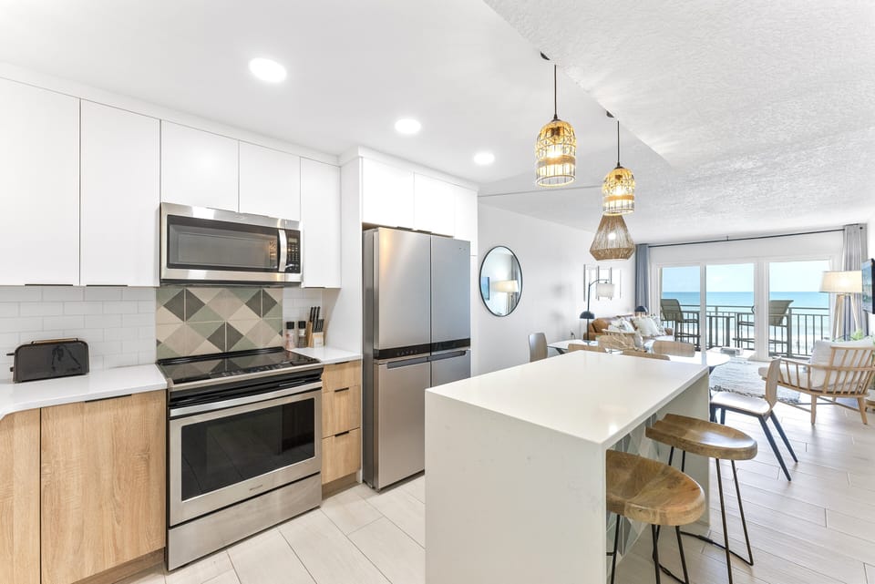 Modern kitchen with sleek stainless steel appliances, a spacious island perfect for cooking meals.