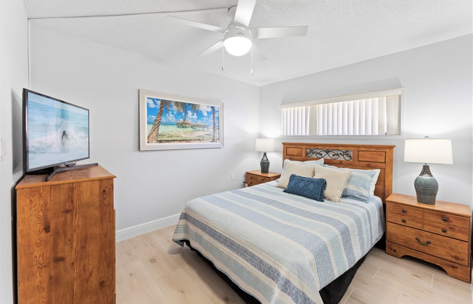 Guest bedroom with a queen bed and TV.