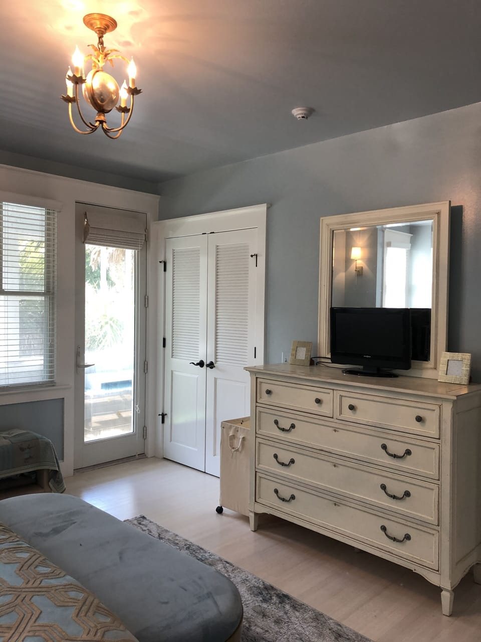 Main house bedroom 1, closet, dresser, Apple TV, screened porch access. 
