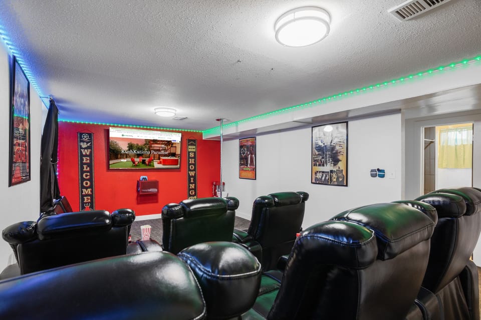 A theater room equipped with ultra-comfy chairs and a large TV, creating the perfect setting for movie nights in supreme comfort.