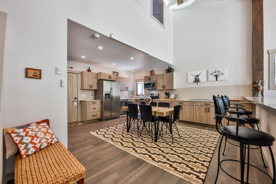 Full and fully stocked kitchen with dining area, bar, table, and chairs.