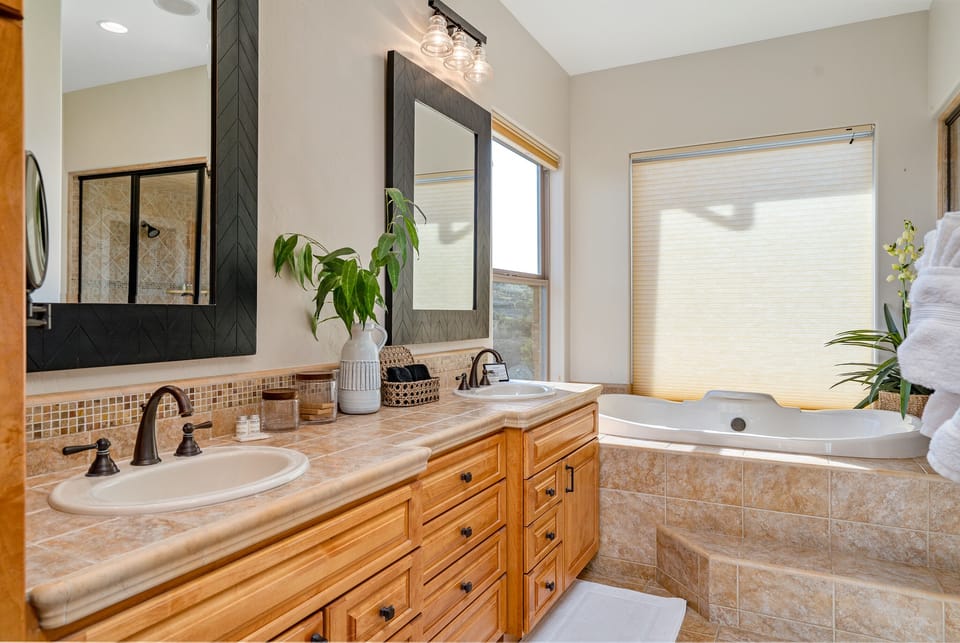 Primary Bathroom: Enjoy a deep soaking tub, double vanity, and separate glass-enclosed shower.