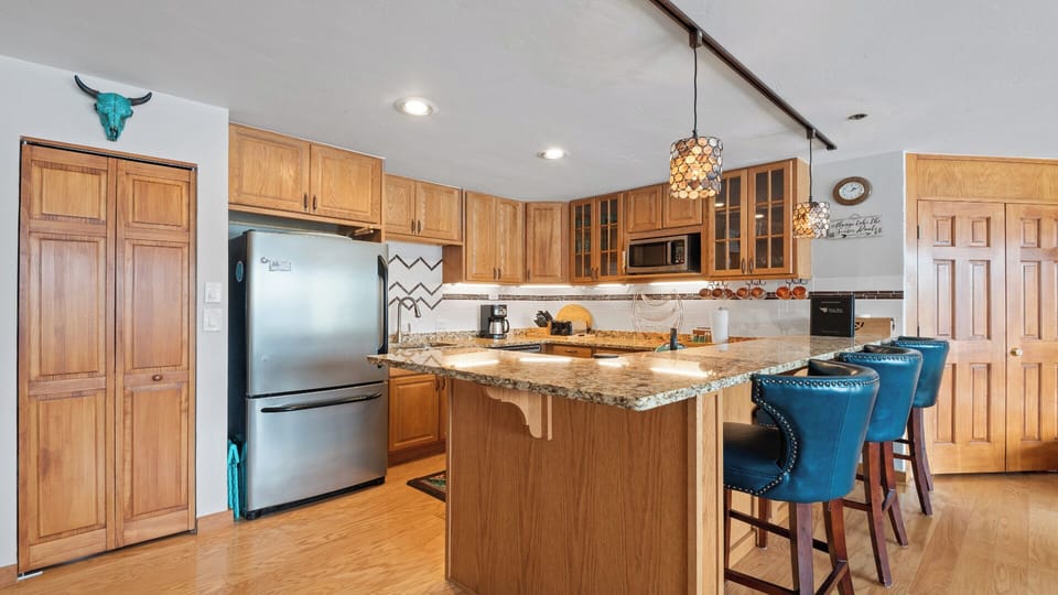 Cook your favorite meals in this fully equipped kitchen with granite countertops, modern appliances, and a welcoming island where you can gather with loved ones over morning coffee or evening snacks.