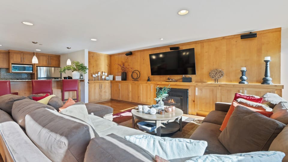 Sink into plush sofas beside a glowing fireplace and enjoy your favorite shows on the large screen in this open, beautifully-appointed living space.