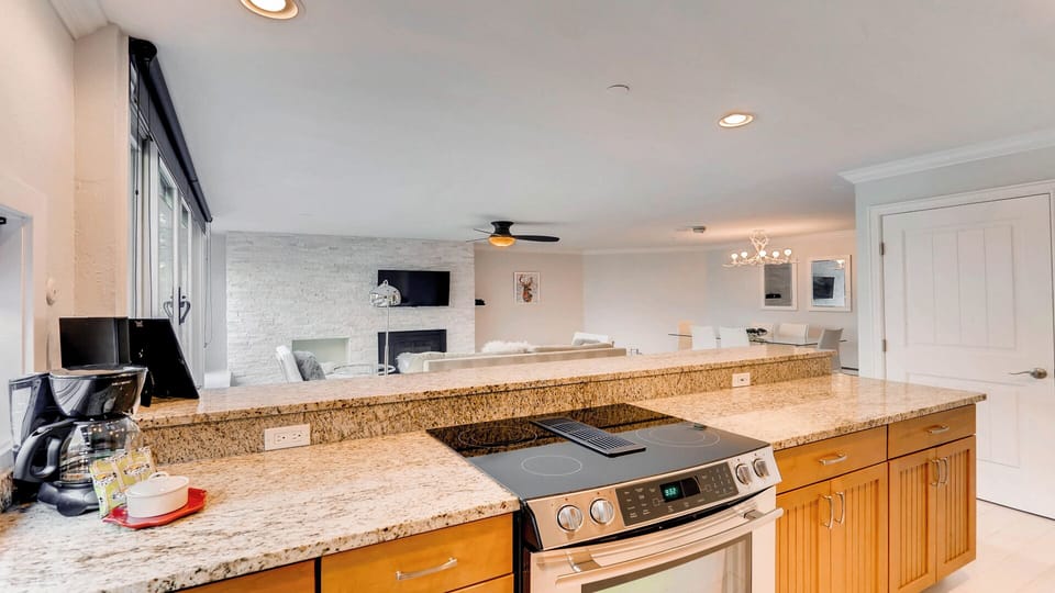 Your spacious kitchen features granite countertops and modern appliances, opening to a stylish living area with a cozy fireplace and plenty of natural light.