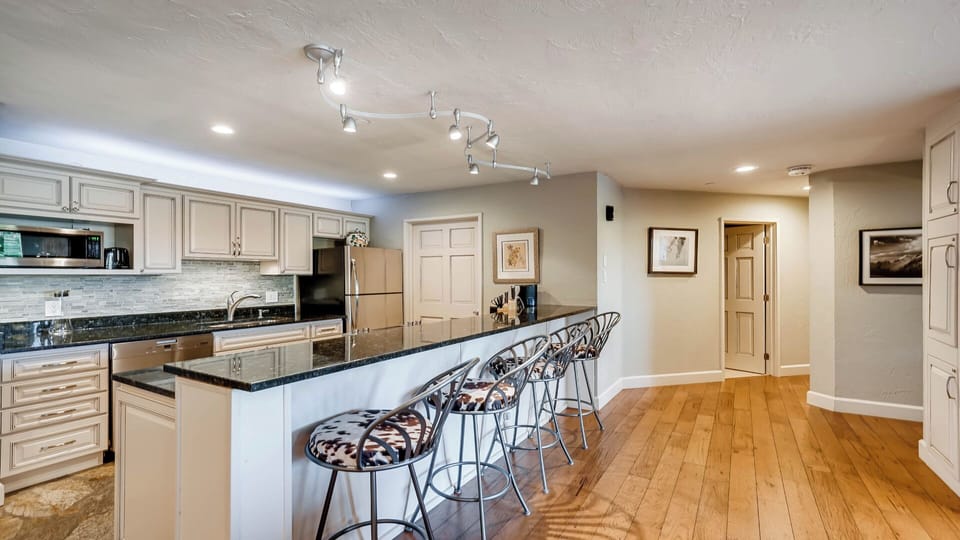 Gather around the spacious kitchen island with seating for everyone. Gleaming countertops, modern appliances, and warm wood floors create your perfect home base for morning coffee and evening meals together.