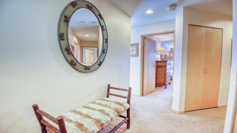 Bright, welcoming hallway with rustic charm connects your living spaces, featuring cozy bench seating and ample closet storage for your belongings.