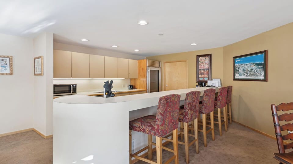 A fully-equipped open kitchen featuring modern appliances, ample counter space, and bar seating—perfect for gathering with friends and family during your mountain retreat.