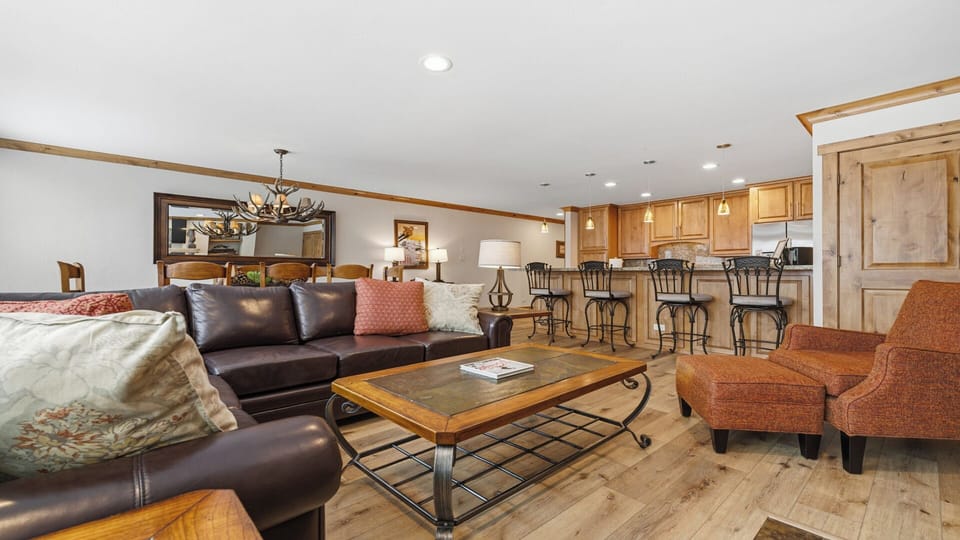 Sink into the leather sofas and feel instantly at home in this open-concept space. Gather around the warm wood dining table, chat at the breakfast bar, or simply unwind with your favorite show.