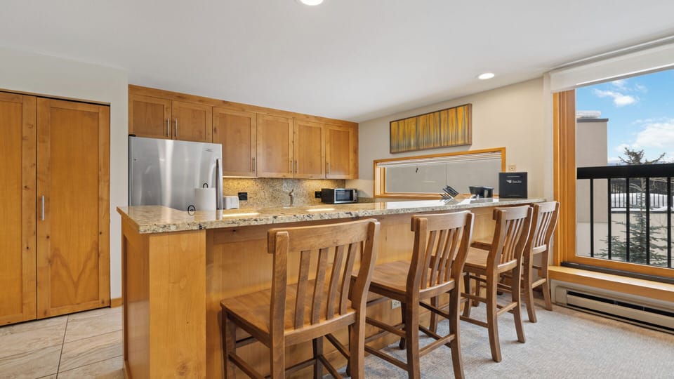 Gather around your spacious kitchen with warm wood cabinetry, granite countertops, and breakfast bar seating. Natural light pours in, while modern appliances make meal prep effortless.