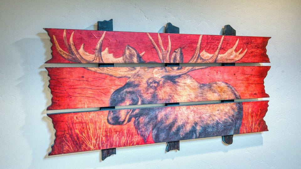 A striking moose artwork adds rustic charm to your space, its bold colors and natural imagery creating a cozy, cabin-inspired atmosphere you'll love coming home to.