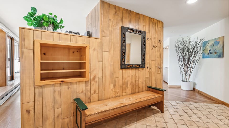 Arrive to warm wooden accents and natural light welcoming you home. This cozy entryway features convenient built-in storage and a peaceful mountain retreat vibe.