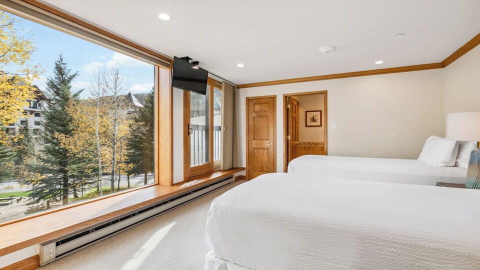 Wake up to stunning autumn views framed by large windows, with soft linens and warm wood accents creating your peaceful mountain retreat.