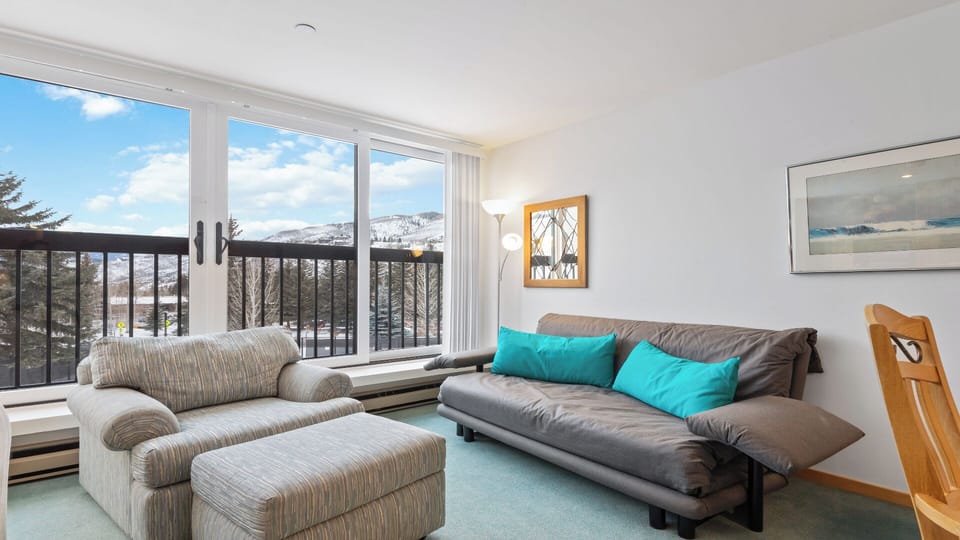 Relax on the comfortable sofas and enjoy stunning mountain views through expansive windows. Bright and inviting, this living area blends cozy seating with natural light and scenic surroundings perfect for unwinding.