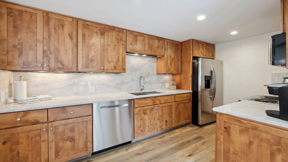 Cook up your favorite meals in this fully equipped kitchen featuring warm wood cabinetry, modern appliances, and plenty of counter space for culinary creations.