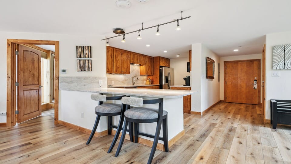 Your open-concept kitchen features warm wood cabinetry, granite countertops, and a spacious island with stylish seating—perfect for cooking and gathering with loved ones.