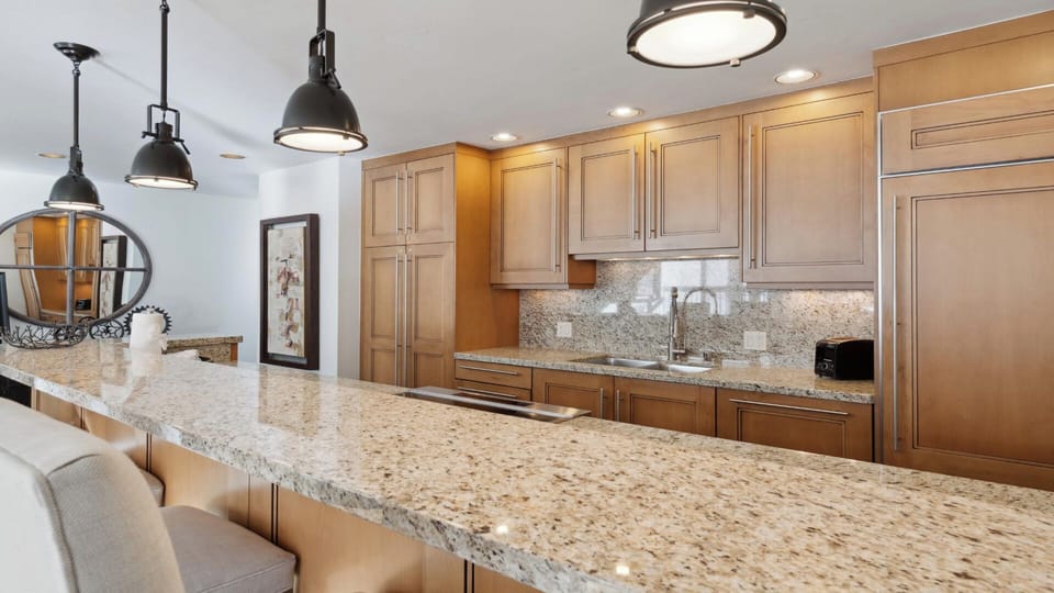 Your gourmet kitchen features elegant granite counters, warm wood cabinetry, and modern appliances—perfect for preparing memorable meals during your stay.