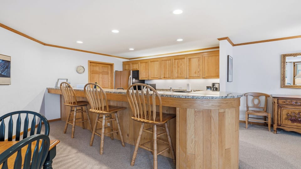 Gather with loved ones at the spacious breakfast bar, where rich wood tones and granite details create a welcoming setting for your morning coffee or casual meals together.