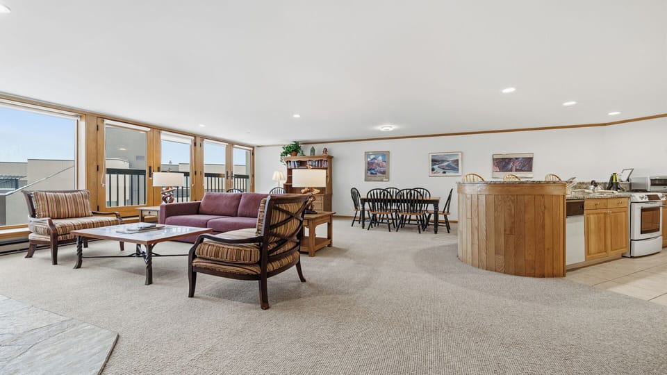 Your open-concept retreat features a cozy living area, dining space, and full kitchen—perfect for gathering with loved ones and enjoying bright, natural light throughout the day.