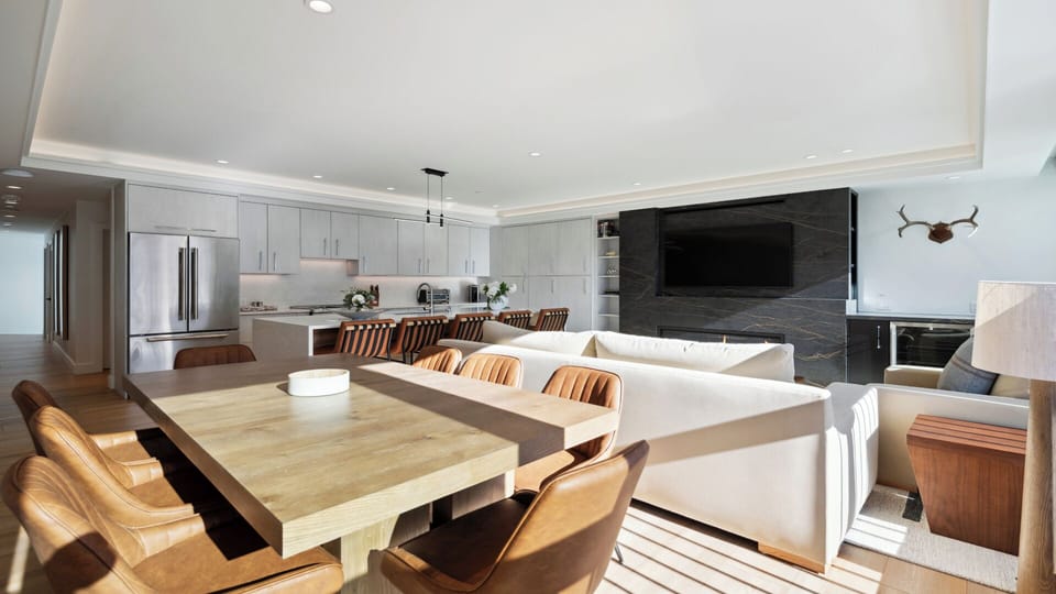 Step into your spacious open-plan haven where sleek modern design meets warm wood accents. Gather around the stunning dining table, unwind on plush seating, and enjoy your favorite shows on the big screen—all in one inviting space.