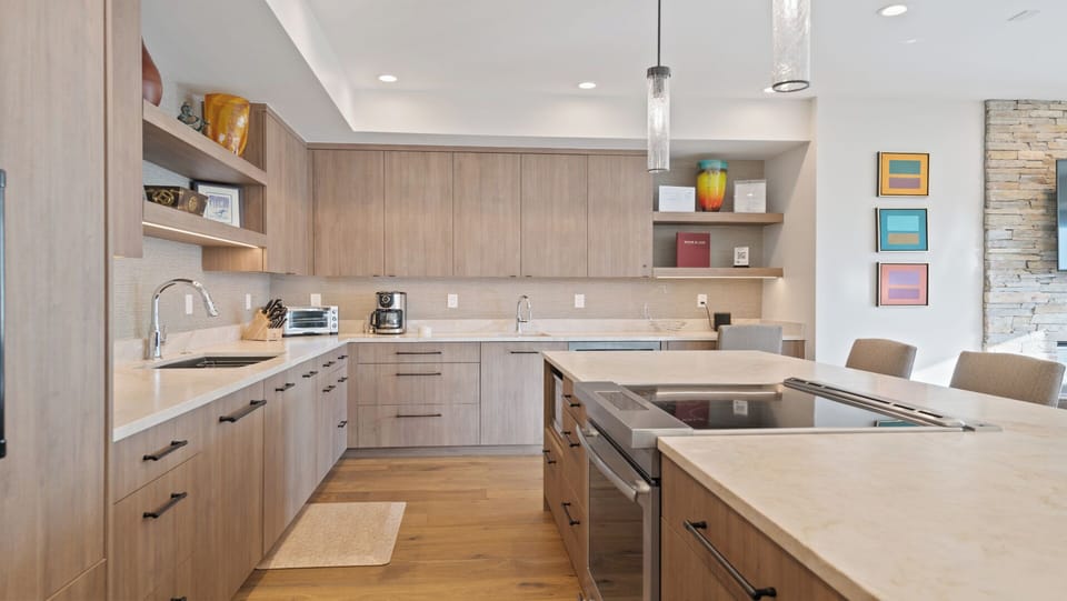 Your modern chef's kitchen blends light wood and warm tones, offering ample counter space, sleek appliances, and stylish open shelving to inspire every meal.