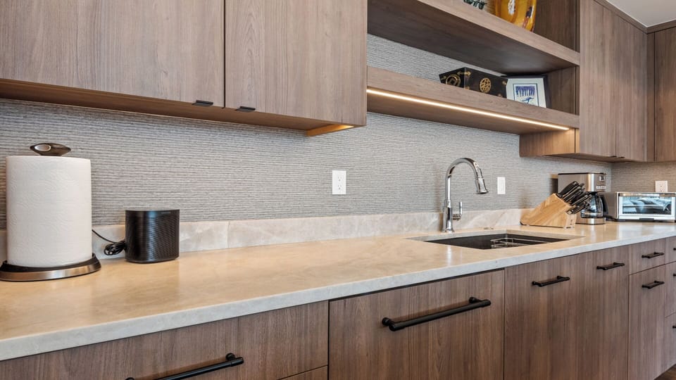 Your modern, fully equipped kitchen makes preparing meals effortless, with sleek countertops, contemporary appliances, and warm ambient lighting to set the perfect mood.
