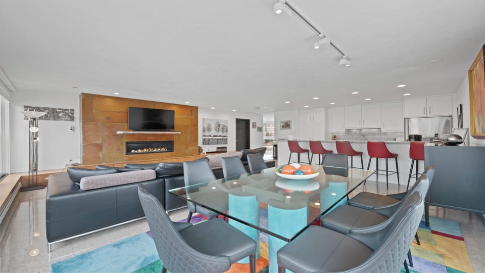 Gather your group in this open-concept space where modern style meets cozy comfort. The sleek fireplace and bright kitchen invite relaxation and lively conversation.