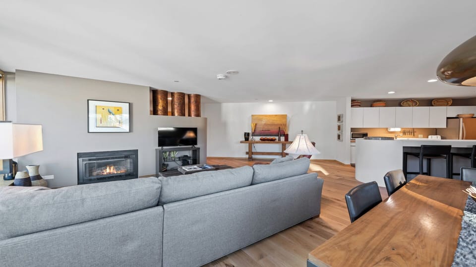 Your open-concept living area blends warmth and style, where you can unwind by the sleek fireplace, share meals at the rich wood table, and enjoy modern comforts in a light-filled space.