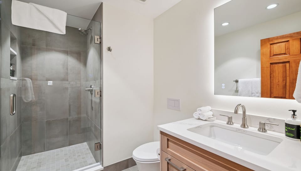 Step into your private en-suite bathroom with a spacious walk-in shower, elegant vanity, and fresh towels waiting—your perfect retreat after a day of adventure.
