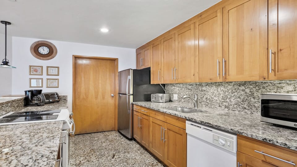 Your fully-equipped kitchen features granite countertops, stainless steel appliances, and plenty of cabinet space to make meal prep easy and enjoyable during your stay.