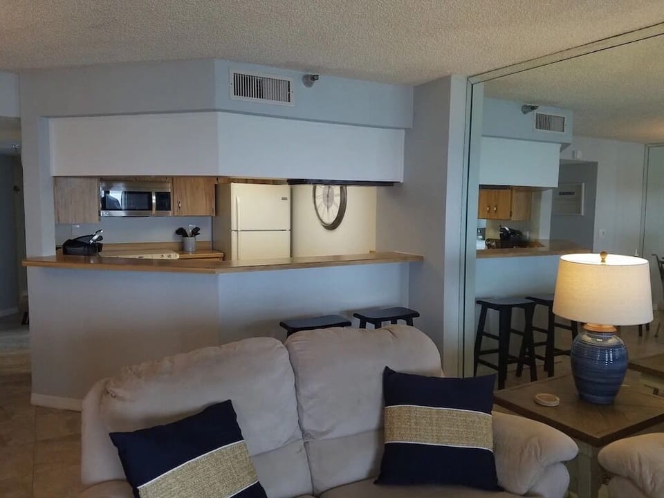 Love seat and recliner sofa in living room as well as a swivel rocker.