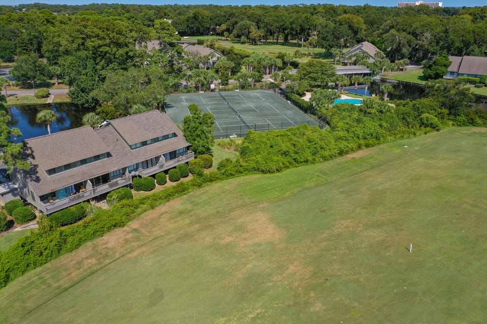 Tennis courts, walking paths, and nearby golf fairways create a resort-style environment that feels both spacious and serene.