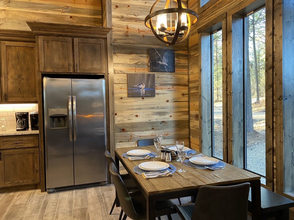The dining room with side by side fridge and table/chairs and bench!