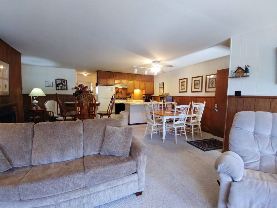 Settle into your spacious open-concept living area, where a plush sofa and recliner invite relaxation, while the full kitchen and dining table create a warm, home-away-from-home gathering space.