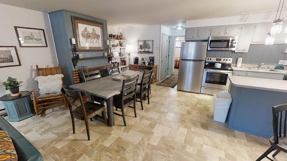Step into your spacious open-concept living area, where a welcoming dining table and fully-equipped kitchen invite you to gather, cook, and relax. Warm touches and comfortable furnishings make this your home away from home.