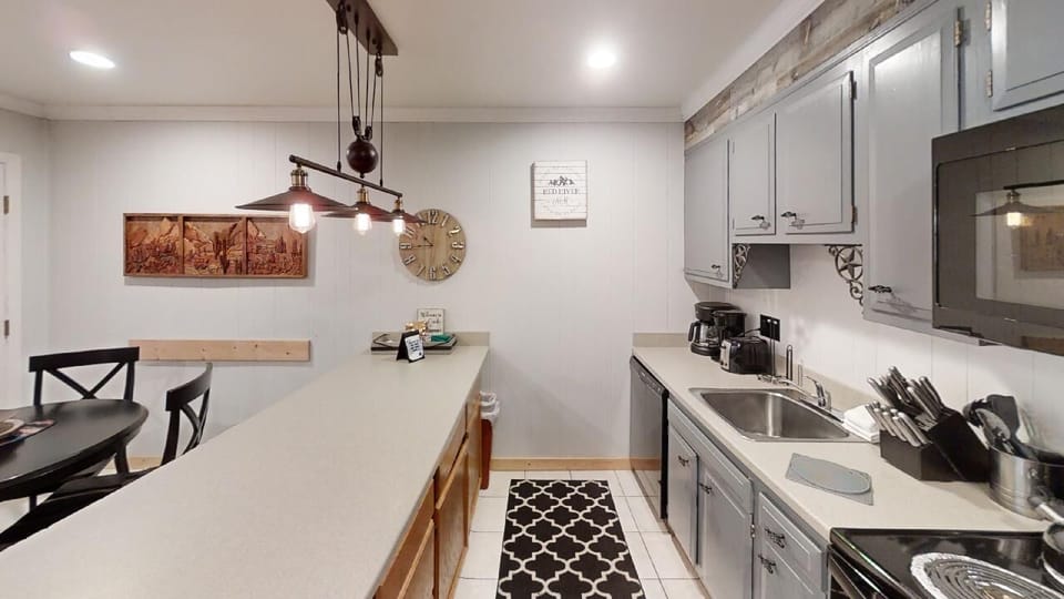 Step into your fully equipped kitchen, where rustic charm meets modern convenience—warm wood tones, stylish lighting, and everything you need to cook up vacation memories.