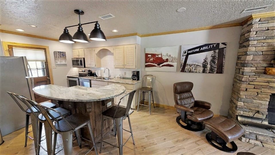 Gather around the kitchen island for meals or unwind in your cozy leather recliner by the stone fireplace. Modern appliances and mountain-themed décor set the perfect tone for your alpine getaway.