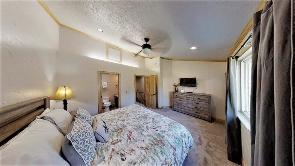 Unwind in your spacious bedroom with plush linens and modern comforts, offering the perfect retreat for rest and relaxation after a day of adventure.