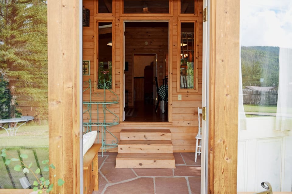 A warm wooden entrance with mountain views welcomes you to your peaceful retreat, where nature surrounds your stay.
