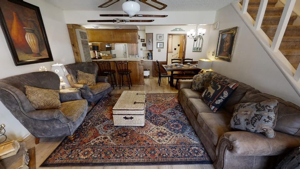 Settle into this cozy living space where you'll find comfortable seating, a full kitchen, and a warm dining area—all ready for your mountain getaway. Relax under the ceiling fan and feel at home.