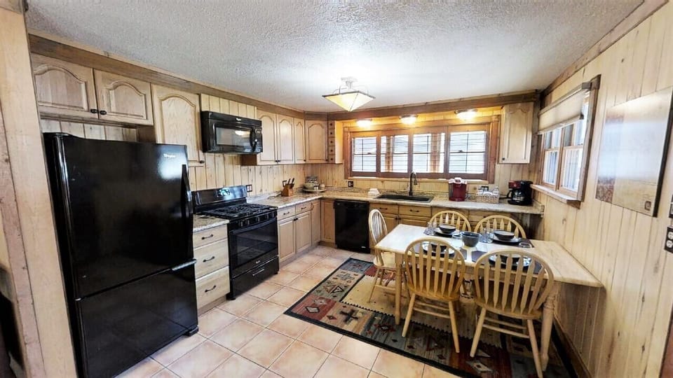 Step into your fully equipped kitchen with modern appliances and a warm dining area—perfect for preparing home-cooked meals and gathering with loved ones over coffee.