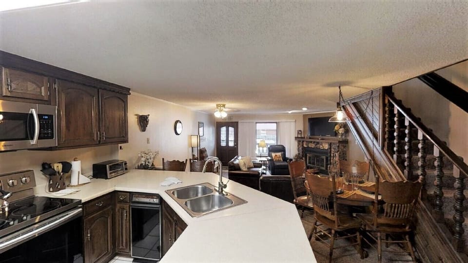 Step into your cozy retreat where warm wood tones and comfortable spaces invite you to settle in. Gather around the dining table, relax by the fireplace, and enjoy all the conveniences of your fully equipped kitchen—everything you need for a memorable stay