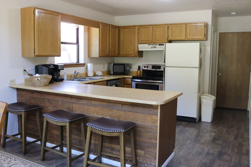 Your fully equipped kitchen offers everything you need to prepare meals at home. A breakfast bar with comfortable seating invites casual dining and morning coffee moments in natural light.