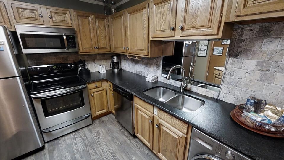 A fully equipped kitchen awaits, where you can prepare meals with stainless steel appliances, sleek granite counters, and everything you need for a comfortable stay.