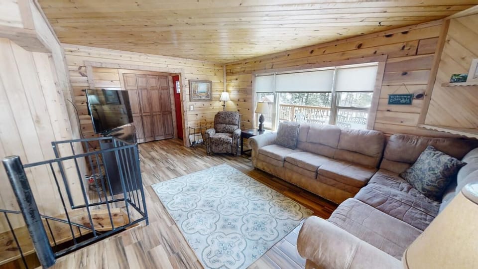 Unwind in your cozy living room with vaulted wood ceilings, plush seating for the whole group, and natural light streaming through large windows—your perfect home base for relaxation.