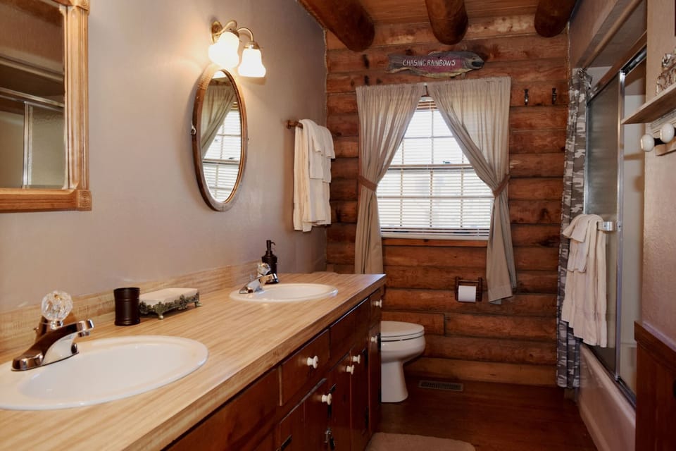 Step into your private retreat where rustic charm meets modern comfort. Dual sinks and a walk-in shower make mornings effortless, while warm wood tones create a cozy, cabin-inspired atmosphere.